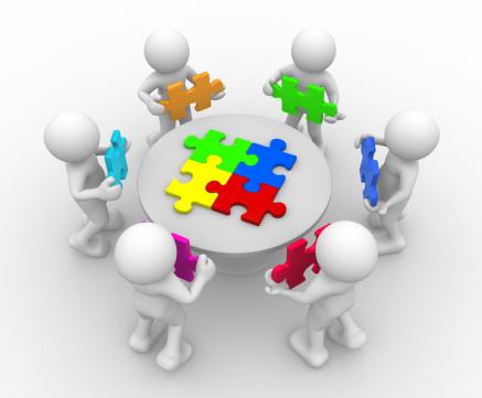 An image of six people working together to solve a puzzle.
